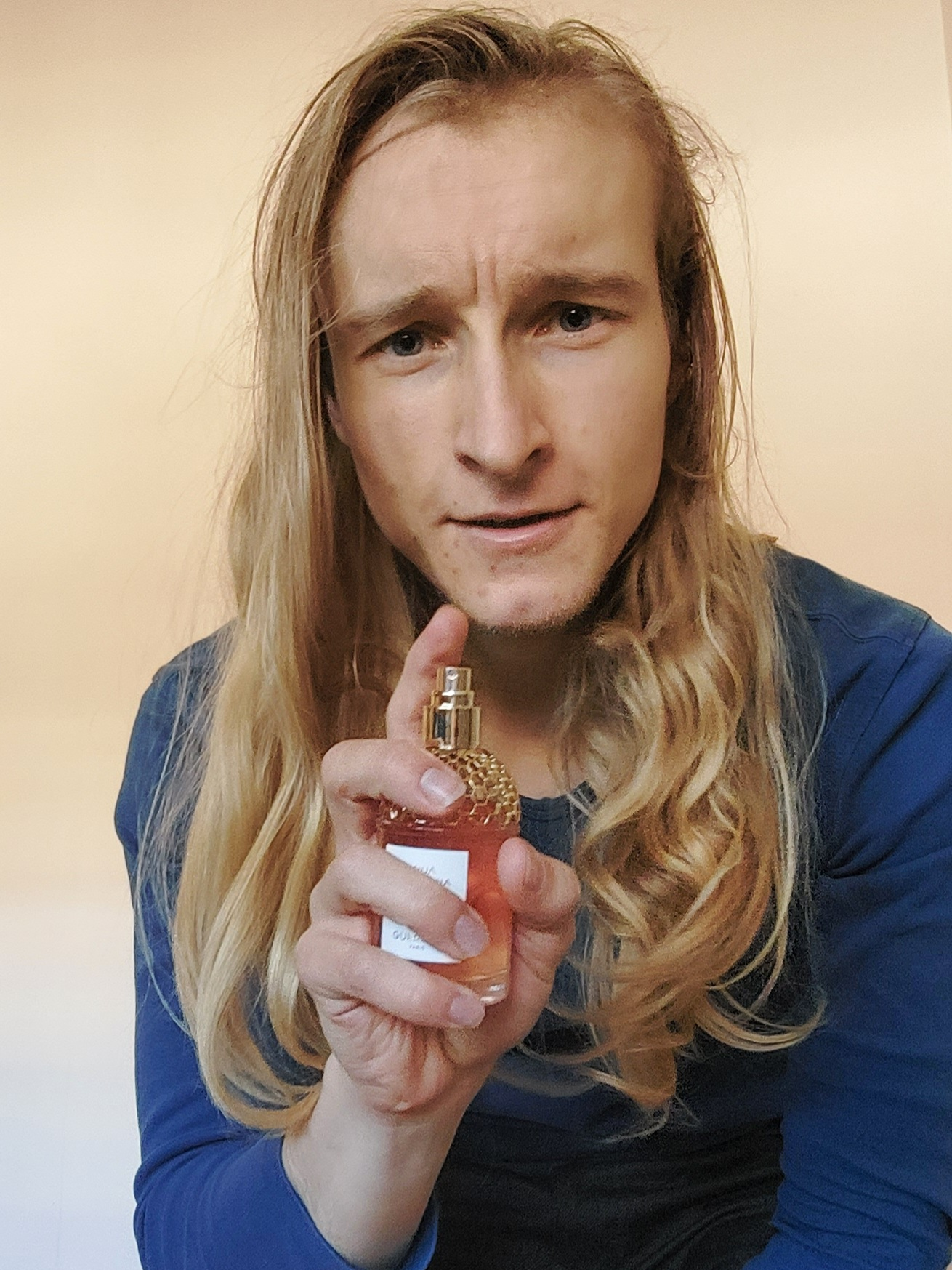Kevin Focke headshot with orange perfume bottle.